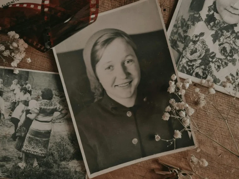 Ett bord med en samling äldre fotografier som föreställer människor från många år sedan.